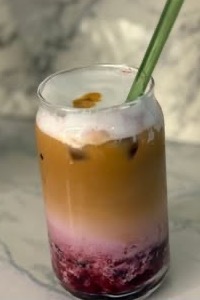 Latte de frutos rojos en vaso de vidrio con popote verde